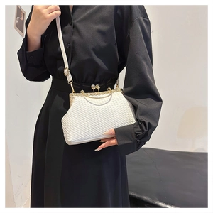 Detail of white woven texture clutch bag with golden frame and pearl clasp on black shirt