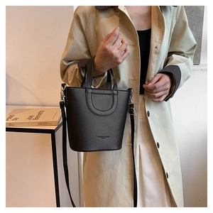 Close-up of black bucket bag featuring lychee grain texture and silver metal hardware