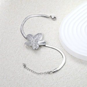 Macro detail of silver petal bracelet featuring snake chain and brushed metal texture