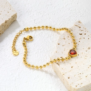 Détail de la gourmette en perles dorées 18K avec zircon en forme de cœur et fermoir mousqueton