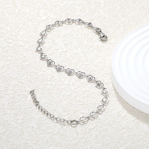 Détail d'un bracelet chaîne à cœurs évidés en argent avec fermoir mousqueton poli