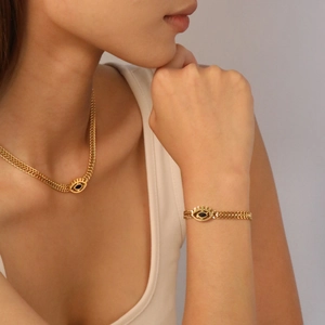 18K gold plated evil eye pendant necklace and bracelet set on a model in a white top