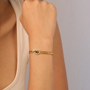 18K gold plated evil eye bracelet with double woven chain on model's wrist