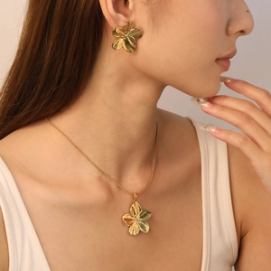 Golden five-petal flower jewelry set featuring brushed texture necklace and earrings