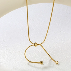 Detail of adjustable gold slider bead on stainless steel snake chain necklace