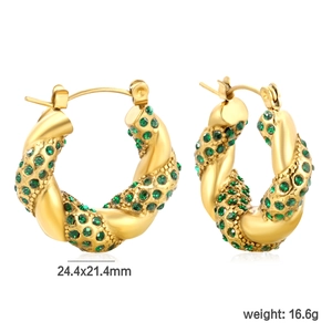 Détail de boucles d'oreilles créoles dorées en C avec pierres précieuses vert émeraude