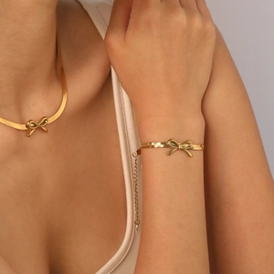 Elegantes Set aus goldener Schlangenkette und Armband mit Schleifen-Anhängern