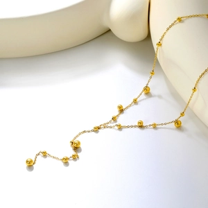 Détail du collier en Y en acier inoxydable plaqué or 18K avec perles dorées élégantes