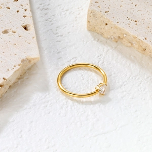Detailed view of a gold-finish minimalist ring with a heart-shaped cubic zirconia gemstone