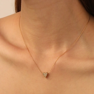 Elegant U-shaped heart necklace in gold with shimmering cubic zirconia on neck
