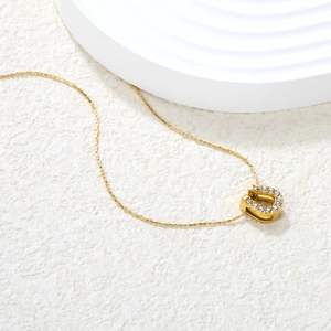 Elegant gold U-shaped horseshoe pendant necklace with pavé cubic zirconia on white background