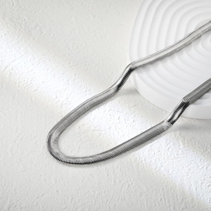 Macro shot of silver flat snake chain necklace with high polish stainless steel texture