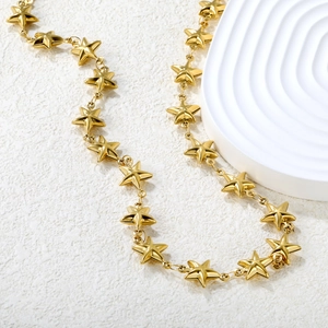 Collana a catena con maglie a stella dorate da donna su un supporto bianco minimalista