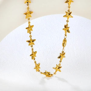 Set di collane a stella in oro 18 carati lucido su una piattaforma bianca minimalista