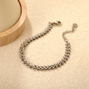 Silver stainless steel twist chain bracelet with lobster clasp on a minimalist background
