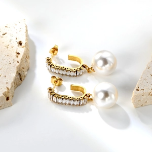 Detail of 18K gold-plated U-shaped earrings with rectangular zircons and a large white pearl