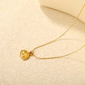 18K gold plated stainless steel shell pendant necklace on textured surface
