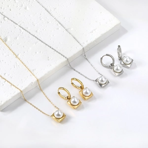 Vue détaillée de l'ensemble de bijoux en perles or et argent avec pendentifs carrés