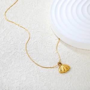 Minimalist gold stainless steel necklace featuring a textured shell pendant on white surface