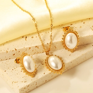 Vintage gold faux pearl jewelry set featuring necklace and earrings on stone pedestal
