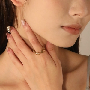 Golden irregular heart branch ring with vine texture on finger close-up view