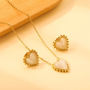Detail of vintage heart necklace and earrings set with cat eye stone and golden beads