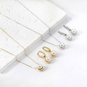 Detailed view of gold and silver imitation pearl necklace and earring jewelry set