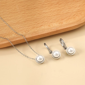 Detailed view of silver stainless steel necklace and hoop earrings with white pearls