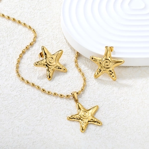 Golden starfish pendant necklace and earrings set with hammered texture on a pedestal
