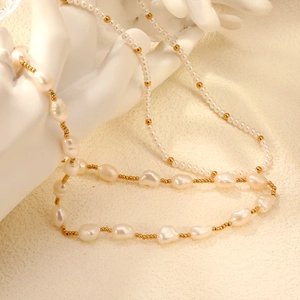 Elegante barokke zoetwaterparelketting met gouden kralen op minimalistisch beeld