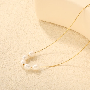 Vue macro d'un collier de perles d'eau douce minimaliste sur une chaîne dorée fine
