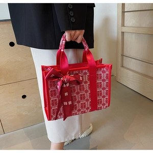 Dettaglio borsa da sposa rossa con jacquard carattere Xi e decorazione fiocco in seta