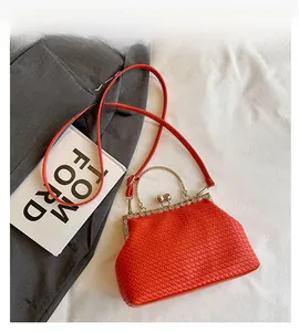 Macro detail of red woven texture and golden kiss-lock closure with diamond trim