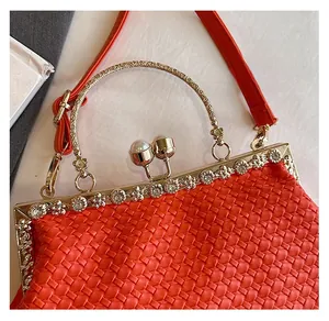 Detailed macro view of vintage red woven handbag with pearl accents and gold metal hardware
