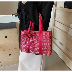 Dettaglio della borsa rossa con jacquard festivo della doppia felicità e fiocco
