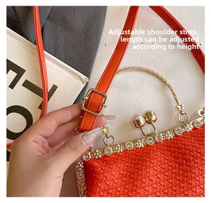 Detail of adjustable leather strap on red woven bag with gold metal buckle