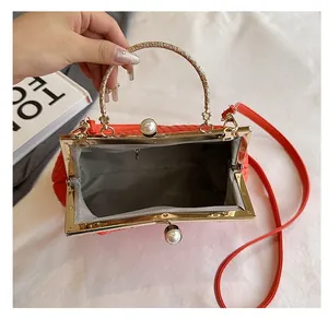 Macro view of red retro woven doctor bag with gold metal frame and pearl clasp detail