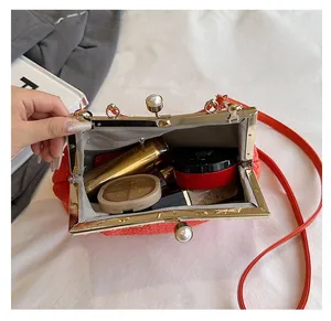 Interior view of red woven evening bag with gold frame and large pearl clasp detail