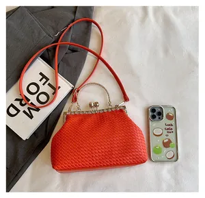 Macro shot of red woven texture and sparkling rhinestone clasp on luxury handbag
