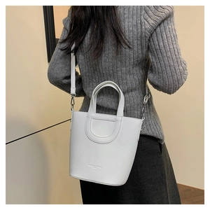 Close-up of white lychee pattern leather bucket bag showing textured finish and stitching