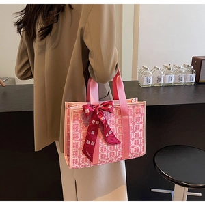 Dettaglio della borsa da sposa rosa con motivo Xi intrecciato e fiocco rosso
