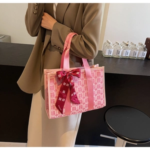 Dettaglio della borsa da sposa rossa con jacquard Xi e fiocco di raso sul manico