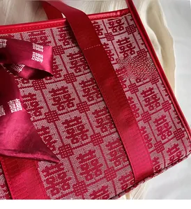 Dettaglio della borsa da sposa rossa in tessuto jacquard Xi e nastro di marca