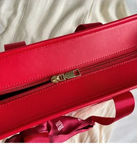 Dettaglio della cerniera della borsa da sposa rossa con nastro di seta festivo