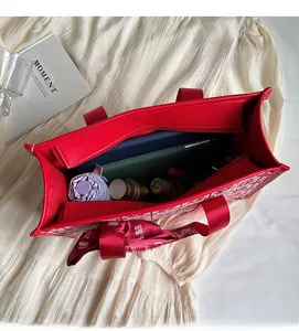 Dettaglio macro della borsa da sposa rossa con ampio interno e chiusura a cerniera lampo