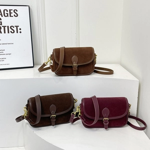 Vintage-Satteltaschen aus Wildleder in Braun und Burgunderrot auf weißen Stufen