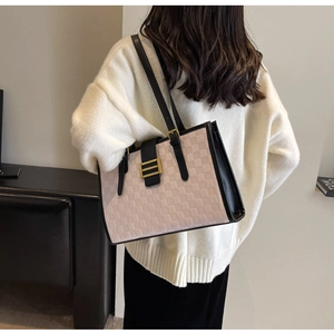 Detail of pink and black checkered tote bag with gold buckle and stylish shoulder strap