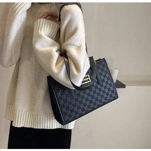 Detailed view of large checkered tote bag featuring a minimalist gold buckle decoration