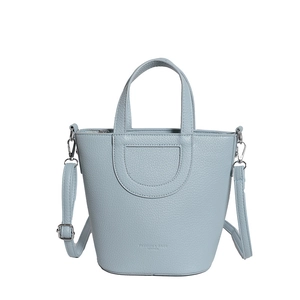 Minimalist blue-grey pebble leather bucket bag with silver hardware and adjustable strap
