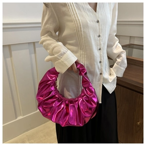 Dettaglio borsa a mano plissettata magenta metallizzato con finitura lucida di lusso